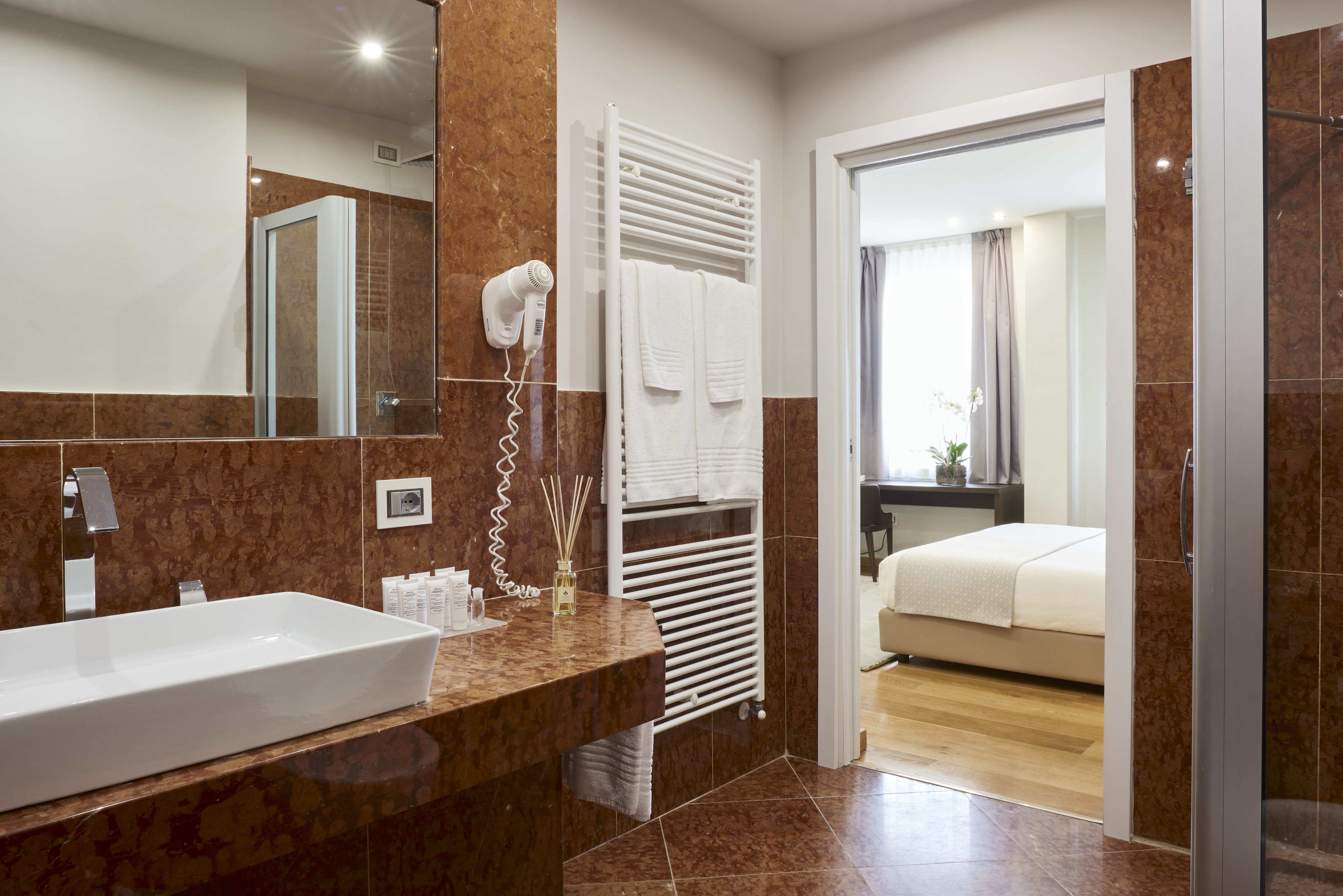 A modern bathroom with a large sink, towel rack, and a hairdryer.