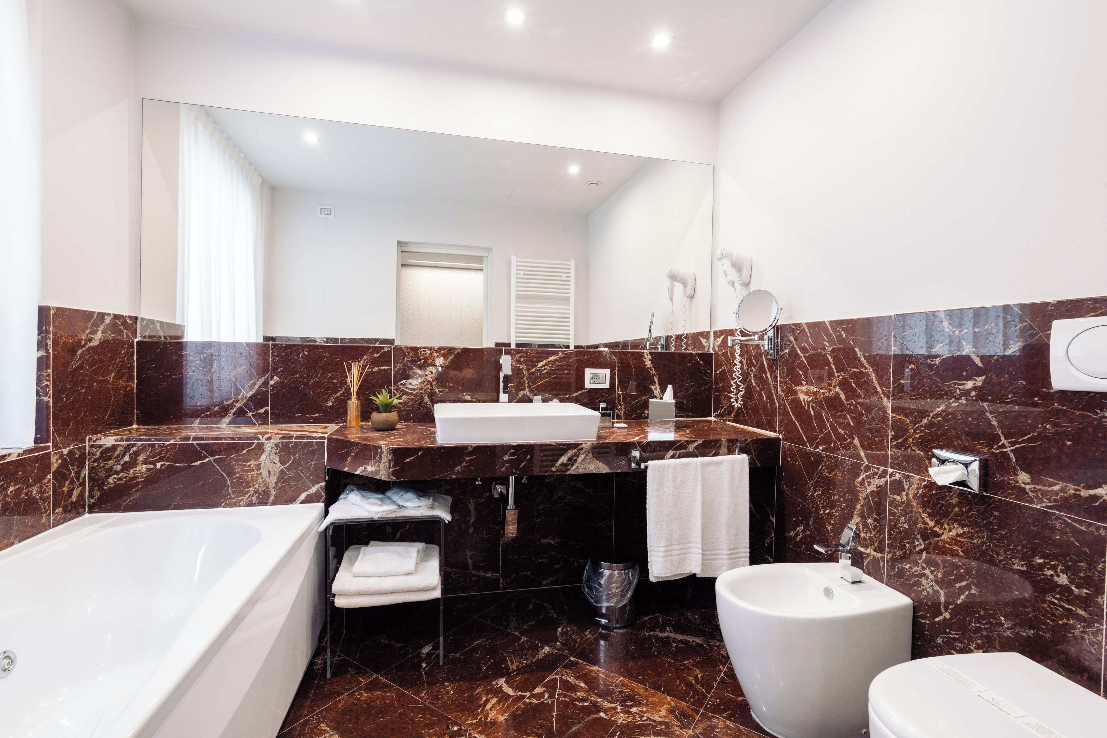 A modern bathroom with a bathtub, sink, and toilet.