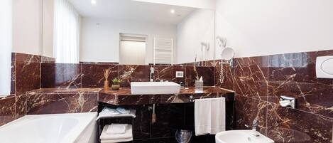 A modern bathroom with a bathtub, sink, and toilet.