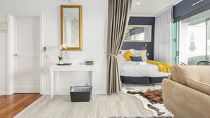 A modern bedroom with a bed, a desk, a mirror, and a large window. - BEST Place Auckland Viaduct (Auckland)