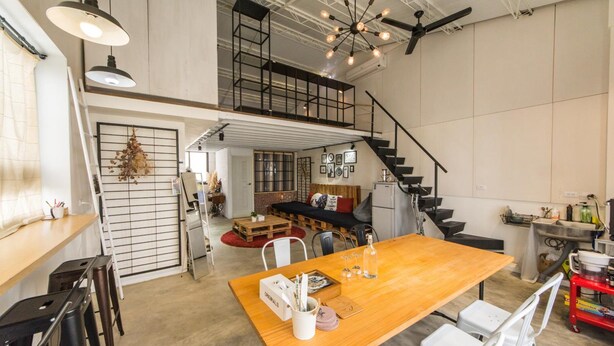 A spacious loft-style living area with a high ceiling, exposed beams, and a mezzanine level. - Memory Traveler (Tainan)