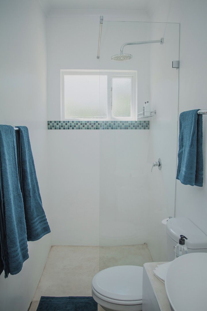 Une salle de bain avec douche, toilettes et lavabo.