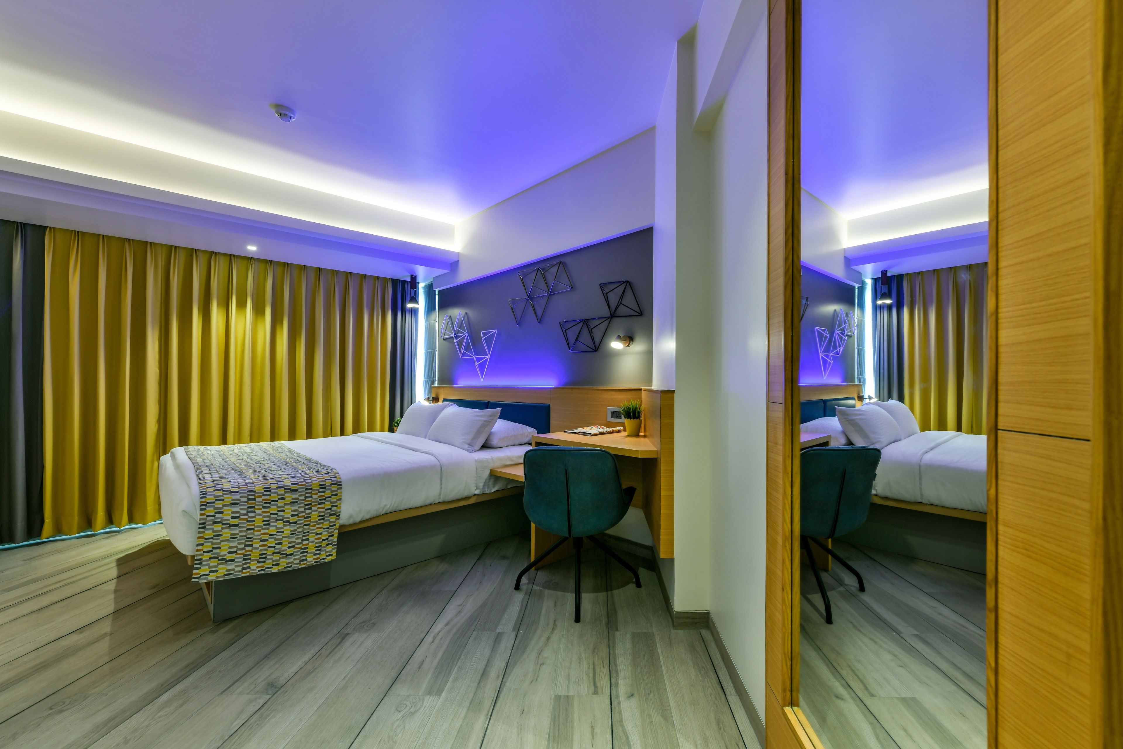 Una habitación de hotel moderna con dos camas, un escritorio y una silla.