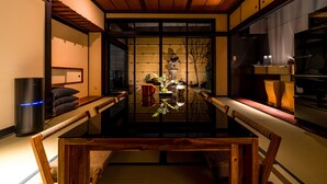 Een traditionele Japanse kamer met tatami vloeren, een lage tafel en een schuifdeur naar een keukenruimte.
