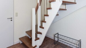 Una escalera de madera con paredes blancas.