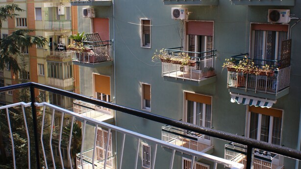 A multi-story residential building with balconies, air conditioning units, and potted plants. - B&B Isole (Naples)