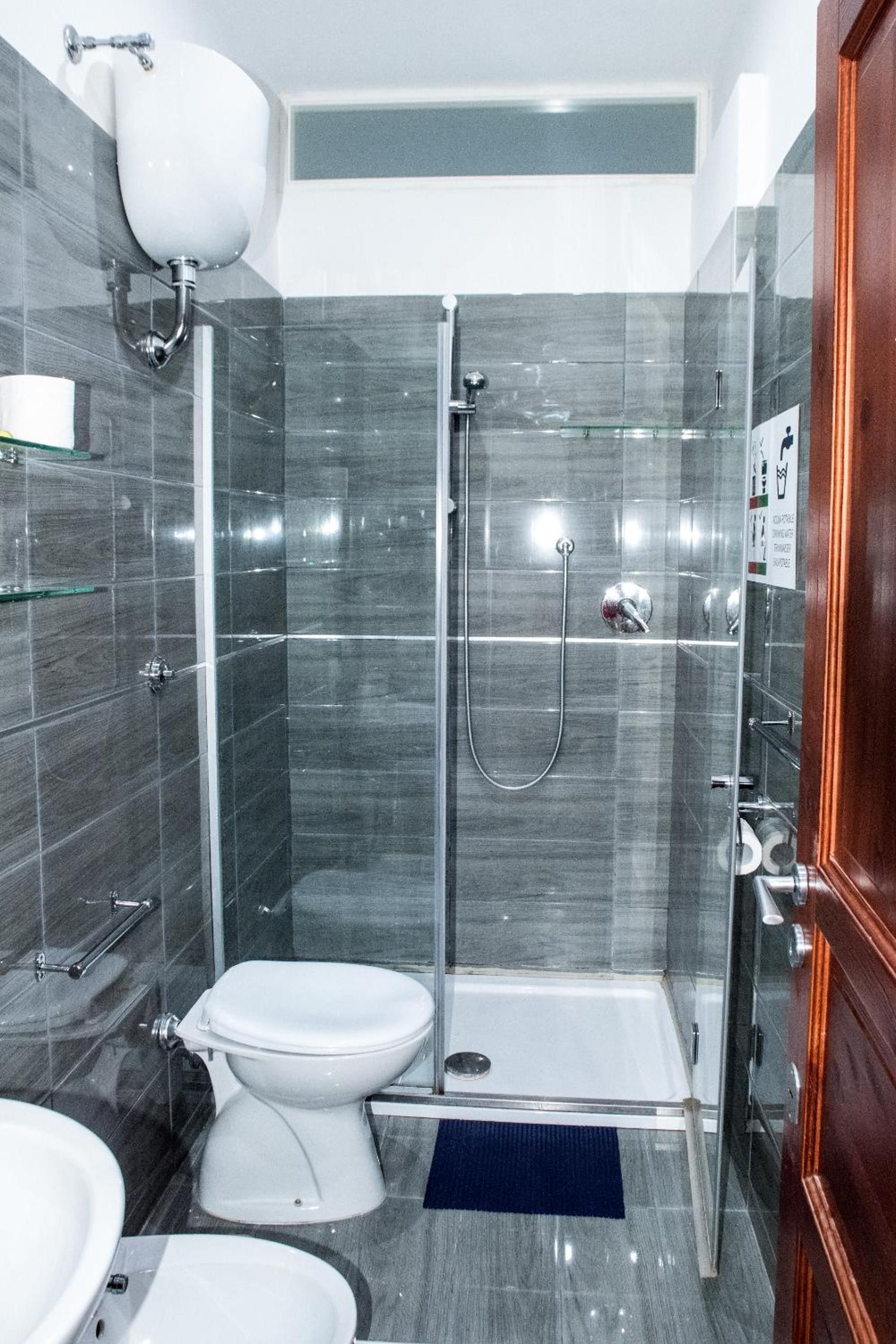 A modern bathroom with a shower, toilet, and sink.