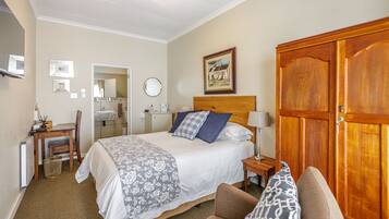 Habitación de hotel con cama, escritorio, silla, armario y baño.