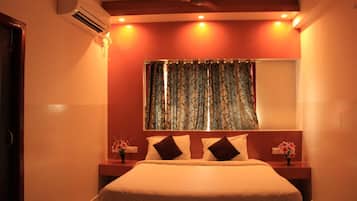 A bedroom with a bed, nightstands, a mirror, and a window with curtains.