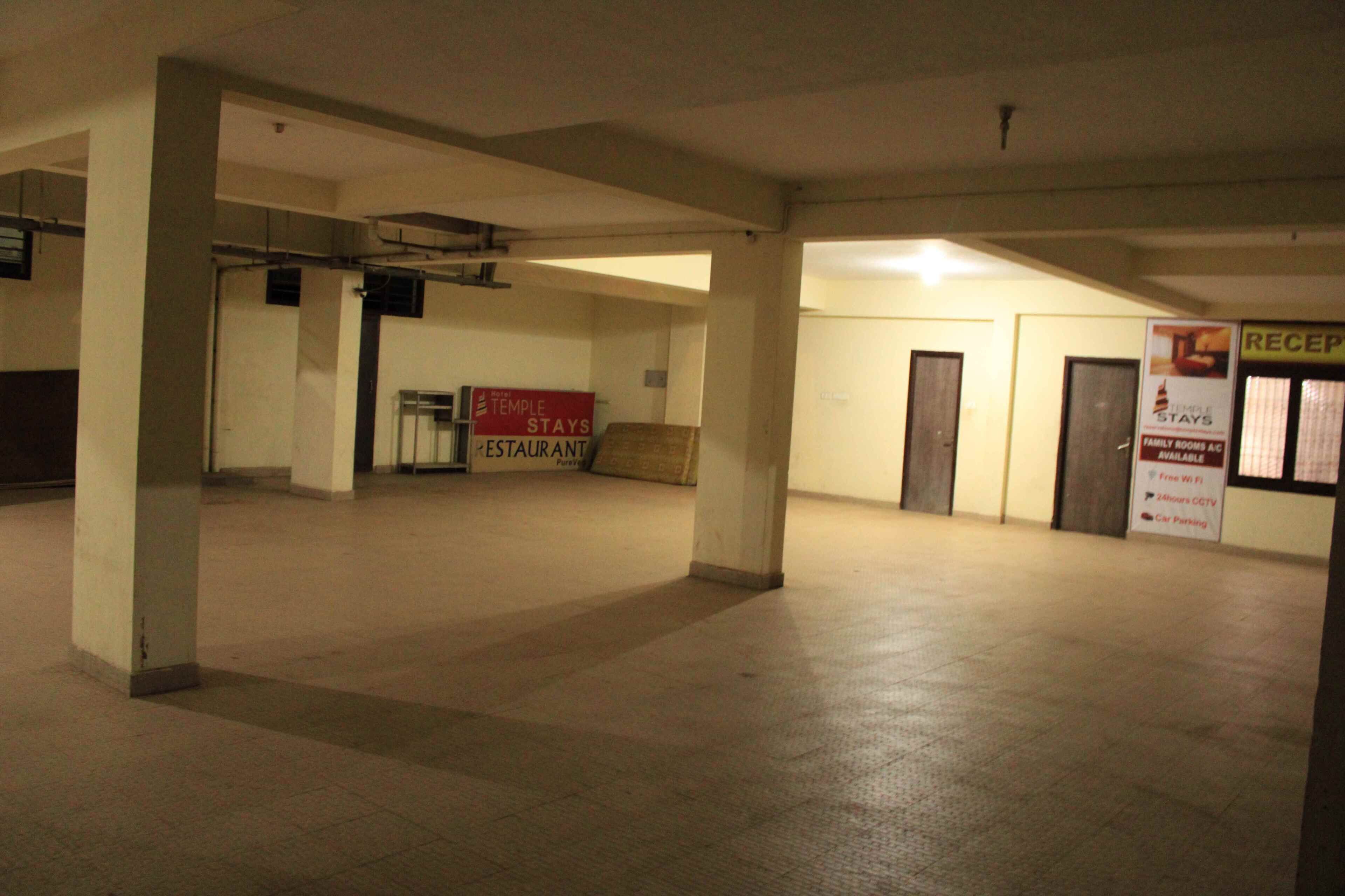A spacious indoor area with a reception desk, a sign for a restaurant, and a sign indicating family rooms and car parking.