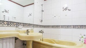 Un baño con dos lavamanos, ducha y un borde decorativo.