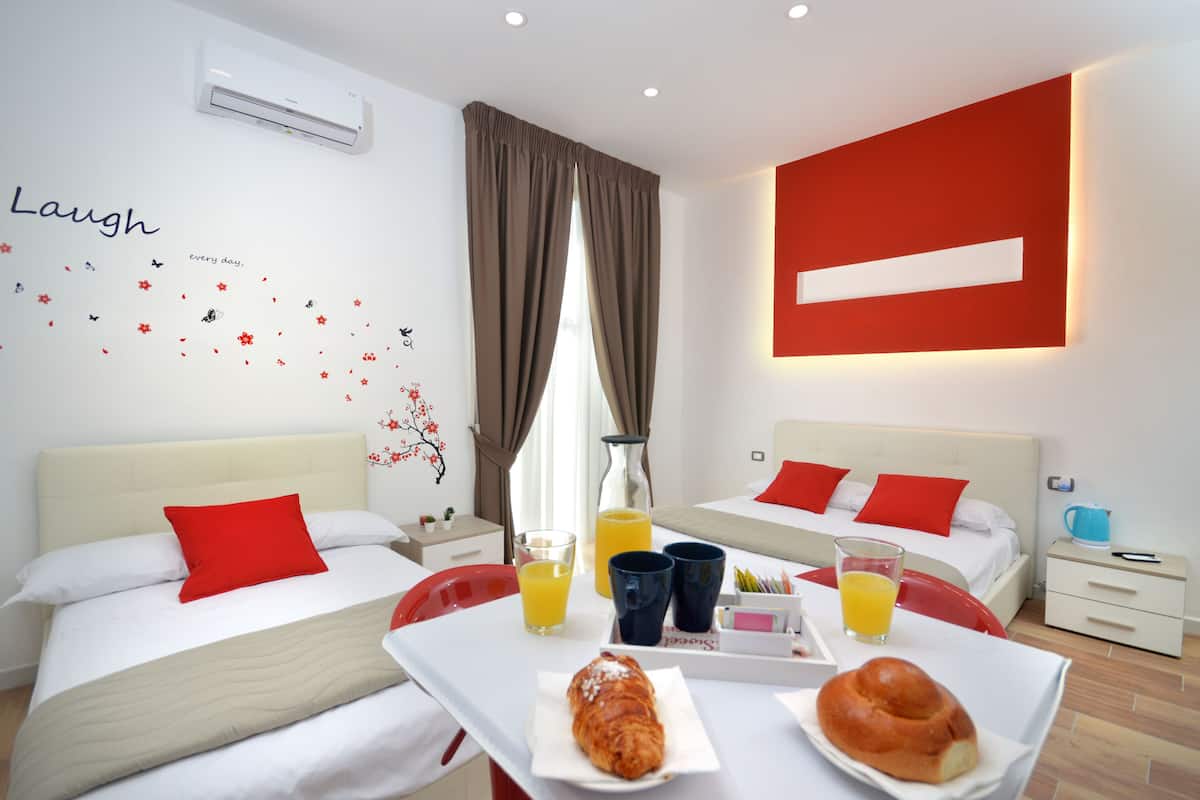 A hotel room with two beds, a breakfast tray, and a wall with a motivational quote.