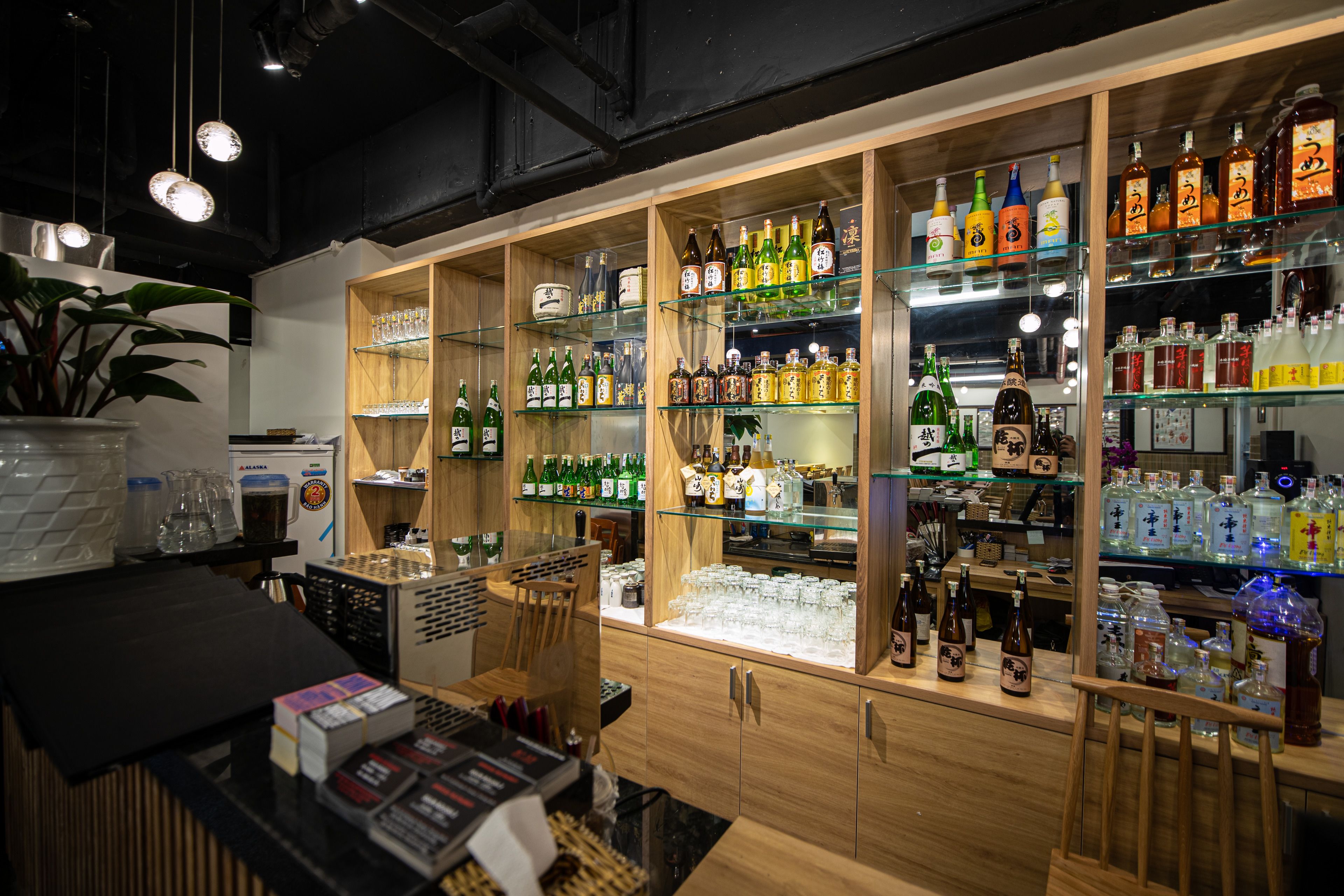 A bar area with shelves of various liquor bottles and glasses.
