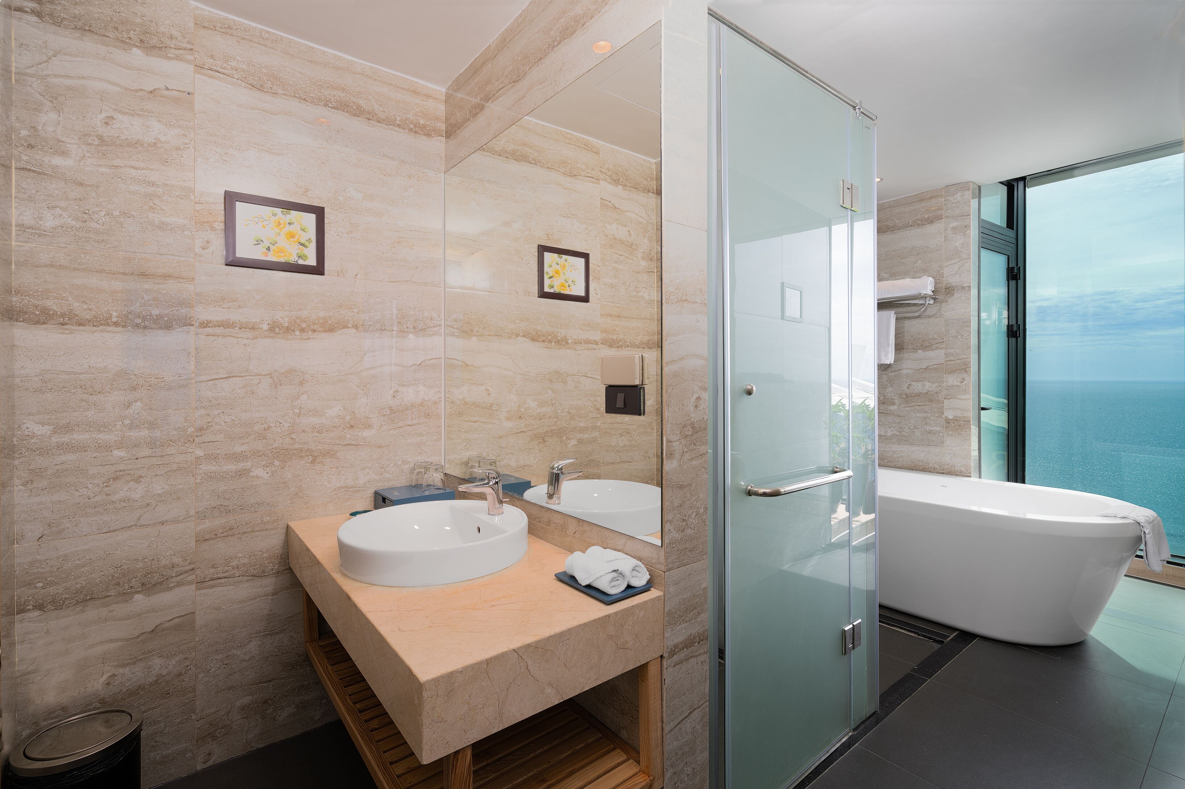 A modern bathroom with a large bathtub, two sinks, and a glass shower enclosure.