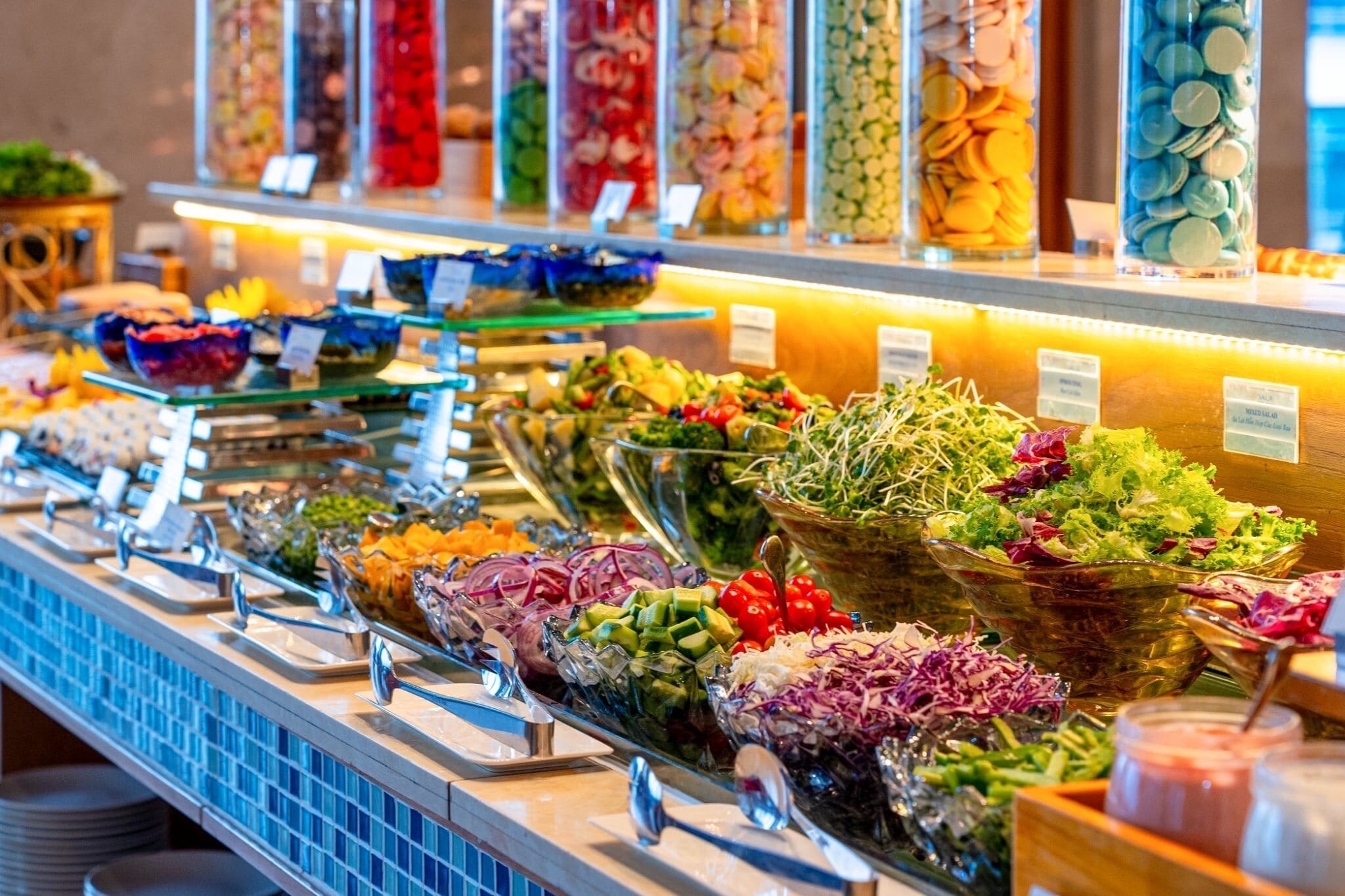 A buffet with various food options including salads, fruits, and other dishes.