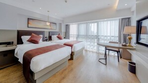 A hotel room with two beds, a desk, and a large window with curtains. - GYA Hotel Jin Ji Lake Oriental Gate (Suzhou)