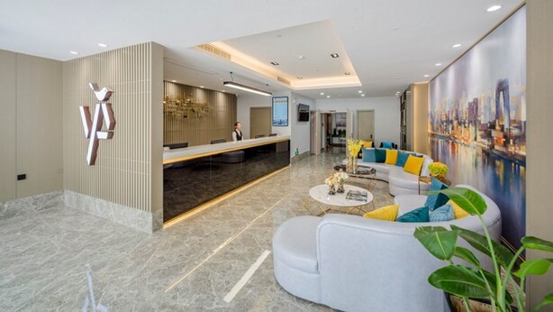 A modern hotel lobby with a reception desk, seating area, and a cityscape mural. - GYA Hotel Jin Ji Lake Oriental Gate (Suzhou)