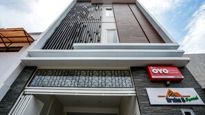 A modern building with a sloped roof, a large window with a geometric pattern, and a sign for "Graha 8 Spanish". - Super OYO Capital O 614 Graha 8 Syariah (Surabaya)