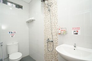 A bathroom with a toilet, shower, and sink. There are signs on the walls with instructions and warnings. - Super OYO Capital O 614 Graha 8 Syariah (Surabaya)