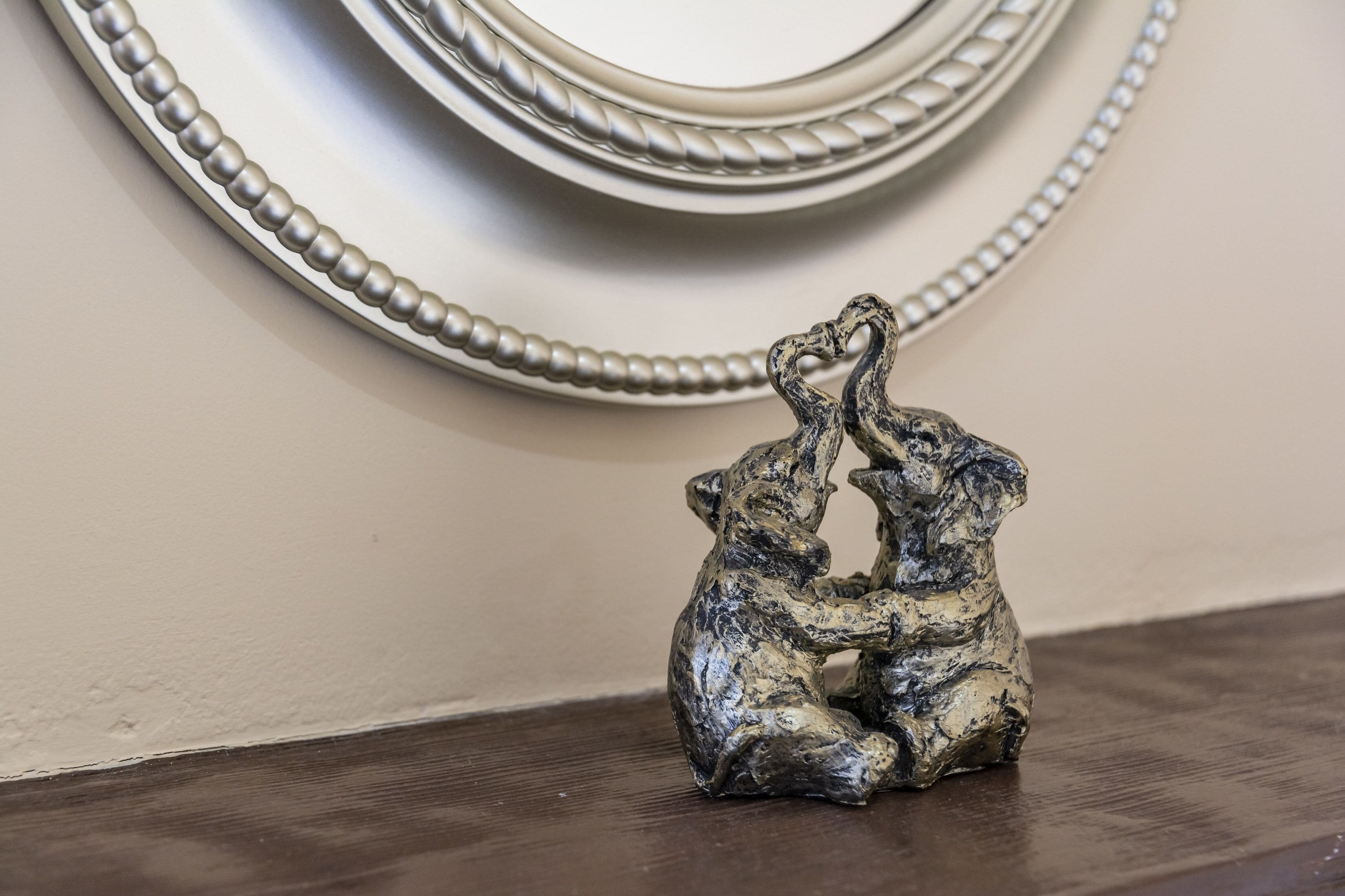 Una piccola statuina scura raffigurante due orsi seduti su un piano di legno.