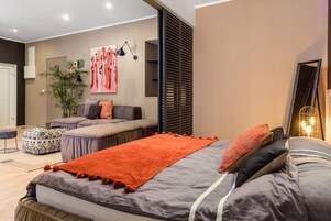 Un dormitorio moderno con una cama grande, un sofá y una mesita.