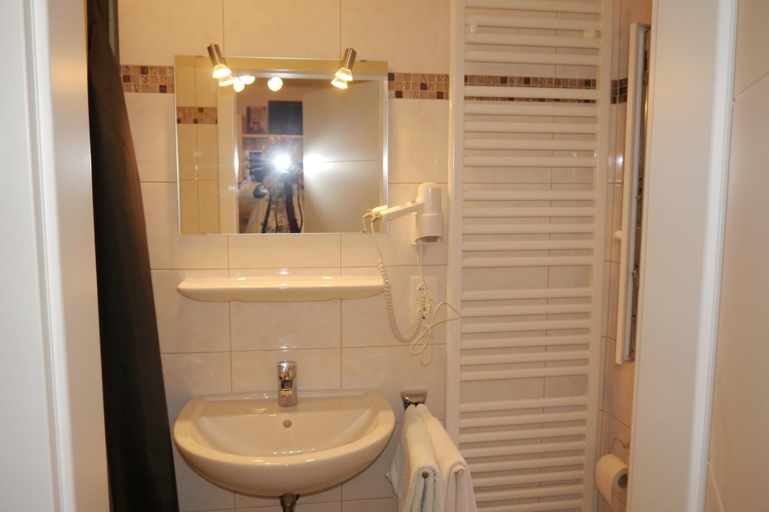 A bathroom with a sink, mirror, and towel rack.