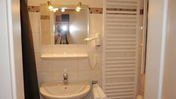 A bathroom with a sink, mirror, and towel rack.