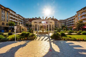 A courtyard with a central fountain, surrounded by multi-story buildings with balconies. - Aparthotel Royal Sun (Sunny Beach)