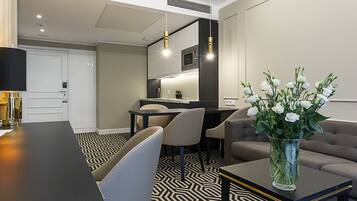 Een moderne hotelkamer met een zithoek, een bank en een bloemenvaas.