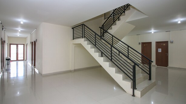 A spacious, well-lit hallway with a modern staircase and clean, tiled floors. - Pondok Bintang (Makassar)