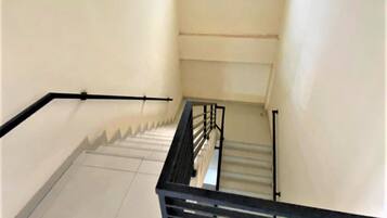 Una escalera con barandillas negras y paredes blancas.