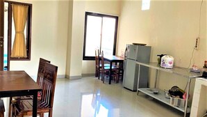 A kitchen with a dining table, chairs, a refrigerator, and a window. - Pondok Bintang (Makassar)
