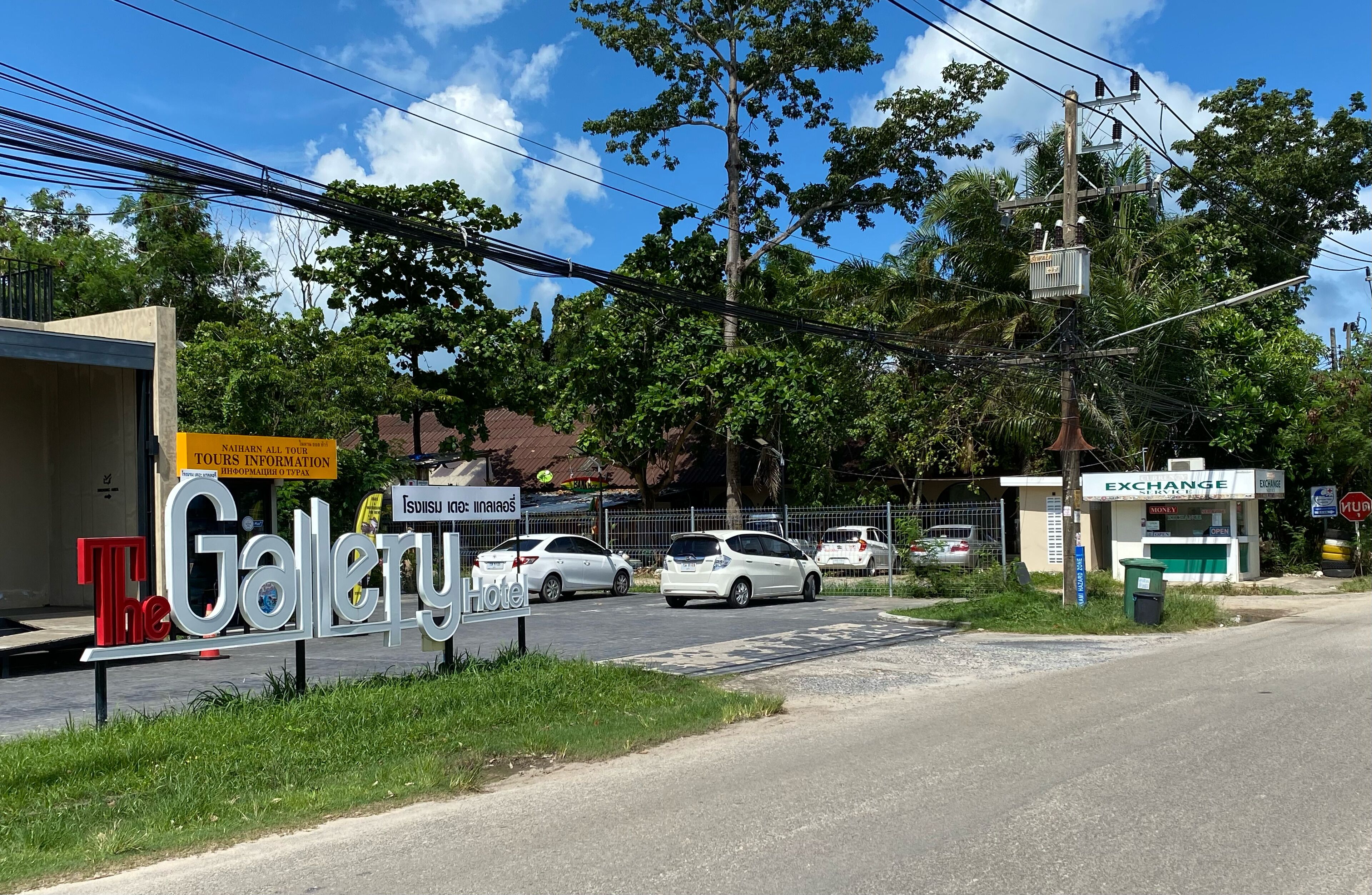 A street view with a sign for 'The Gallery Hotel' and a nearby 'Exchange' store.