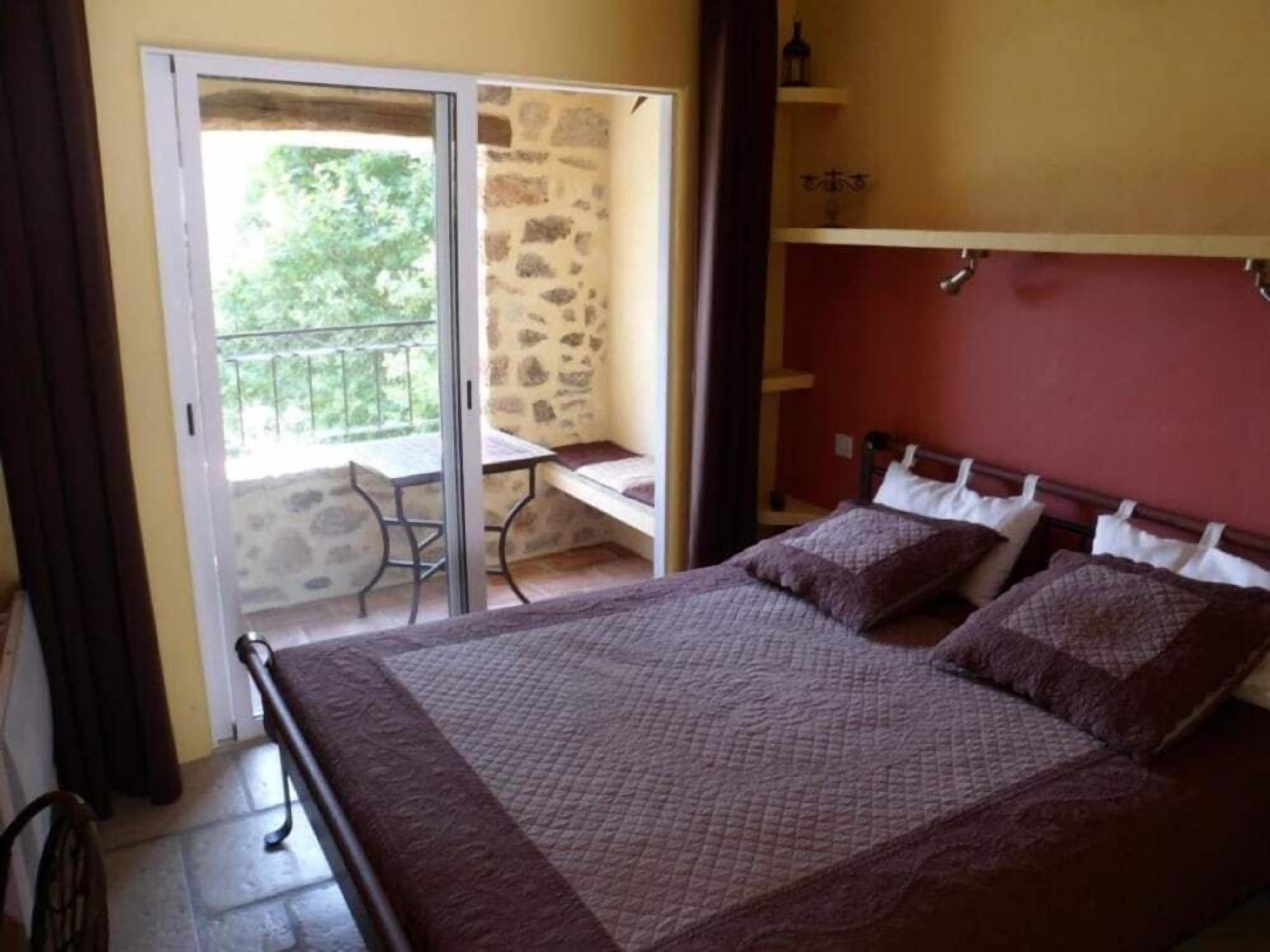 Ein Schlafzimmer mit Bett, Schreibtisch und Balkon.