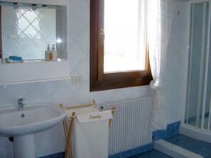 A bathroom with a sink, mirror, window, and a towel rack labeled "Laundry."