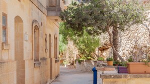 A narrow alleyway with stone buildings, a tree, and potted plants. - Ta Danjela Villa Sleeps 8 With Pool (Xaghra)