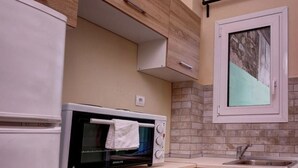 Eine kleine Küche mit Einbauofen, Spüle und Holzschränken.