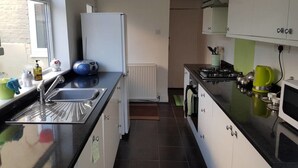 A modern kitchen with a black countertop, white cabinets, a built-in oven, and a window with a view of the outside. - House - Sleeps 4 - Pets Ok - Parking - Garden (Guisborough)
