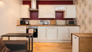 A compact kitchen with white cabinets, a stainless steel range hood, a microwave, a toaster, and a coffee maker. - Luxury 1bedroom Lodge in Prestwich (Manchester)