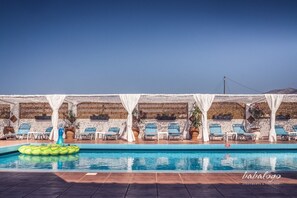 A pool area with lounge chairs and a floating platform. - Babalogo Apartments (Hersonissos)