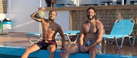 Una piscina al aire libre de temporada, tumbonas