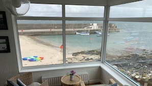 Una habitación con muebles de mimbre, vista a la playa y ventana con vista al mar.