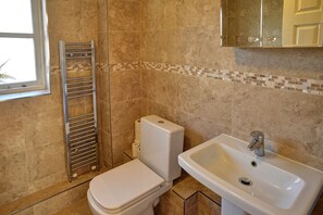Bathroom features a white toilet, sink, and towel rack.