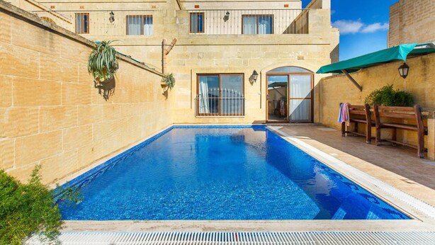 A two-story building with a swimming pool in the courtyard. - Villa Ta Debora Sleeps 7 With Pool (Xaghra)