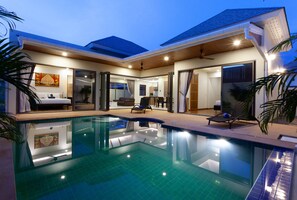 Uma casa moderna com piscina, espaços de convívio amplos e área de jantar.