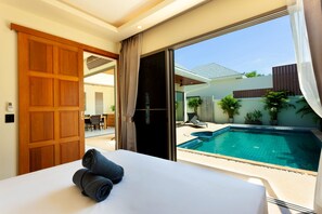 A hotel room with a bed, a view of a swimming pool, and a sliding door to the outside. - Tropical Bliss at Boutique Villa Sequoia (Rawai)