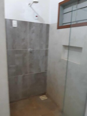 A small, enclosed shower area with tiled walls and a glass door.
