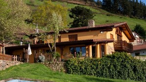 Ein traditionelles Chalet mit Steinfundament, Holzbalkonen und einem geneigten Dach.