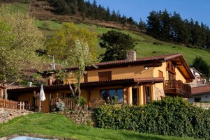 Una chaleta tradicional con base de piedra, balcones de madera y techo inclinado.