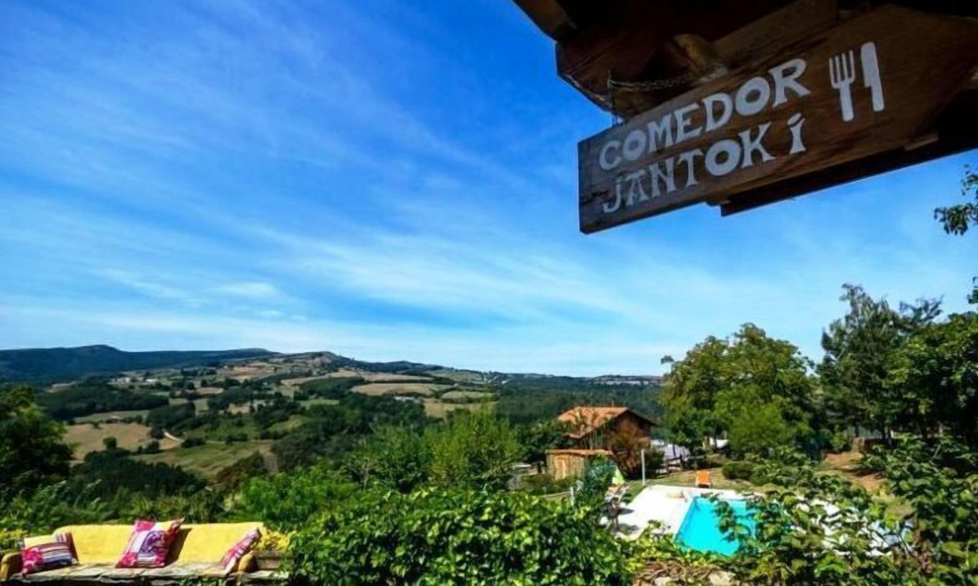 A view of a rural landscape with a sign reading "COMEDOR JANTOKI".